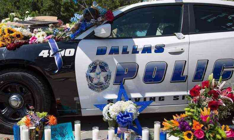 Flores e velas adornam o memorial fora da sede da polcia de Dallas(foto: AFP / Laura Buckman )
