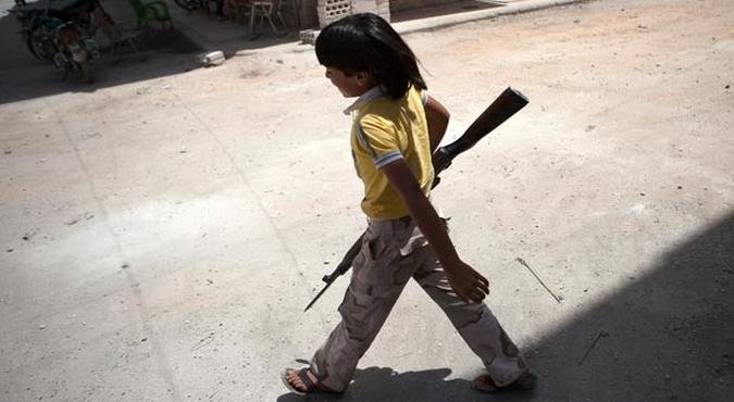 Crian�a carrega rifle para ajudar grupo dos 