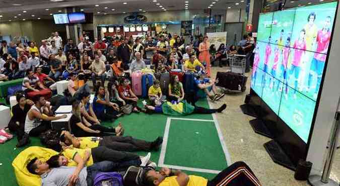 Turistas e passageiros do aeroporto de Viracopos, em Campinas, acompanham jogo do Brasil contra a Colombias pelas quartas-de-final(foto: AFP PHOTO / JEWEL SAMAD )