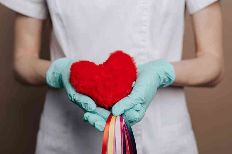 Médica segurando um coração de pelúcia para incentivar os cuidados com a saúde cardiovascular (foto: Karolina Grabowska/Pexels)