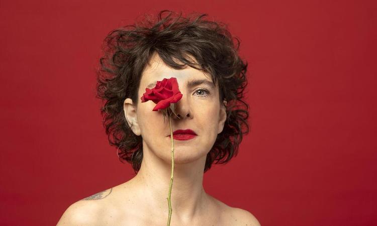 Cantora Adriana Calcanhotto segura uma rosa