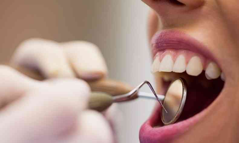 dentista olha boca de paciente