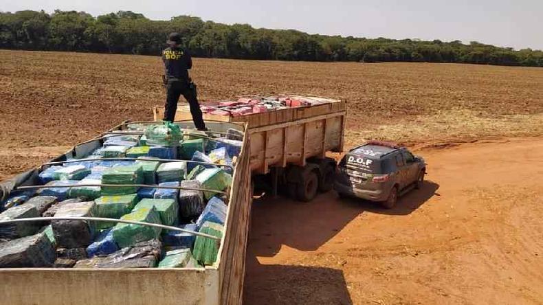 Apreensões de drogas são celebradas por Bolsonaro(foto: SeComSoc DOF/Sejusp) policial em cima de caminhão com pacotes de drogas apreendidos