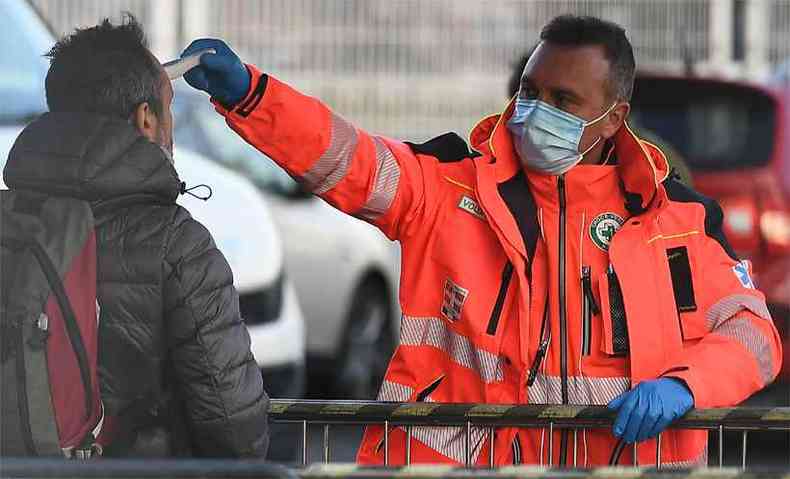Um agente de sade checa a temperatura de um torcedor ao chegar ao estdio do Juventus, em Milo, cidade colocada em quarentena pelo governo italiano(foto: VINCENZO PINTO / AFP)