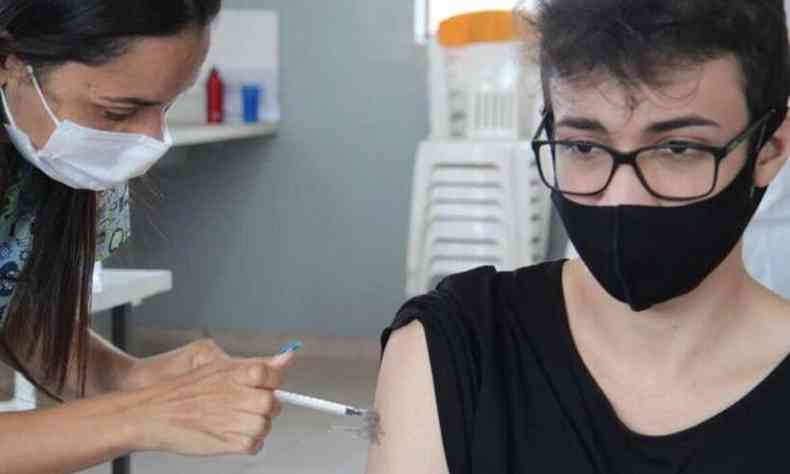 Enfermeira aplica vacina em jovem