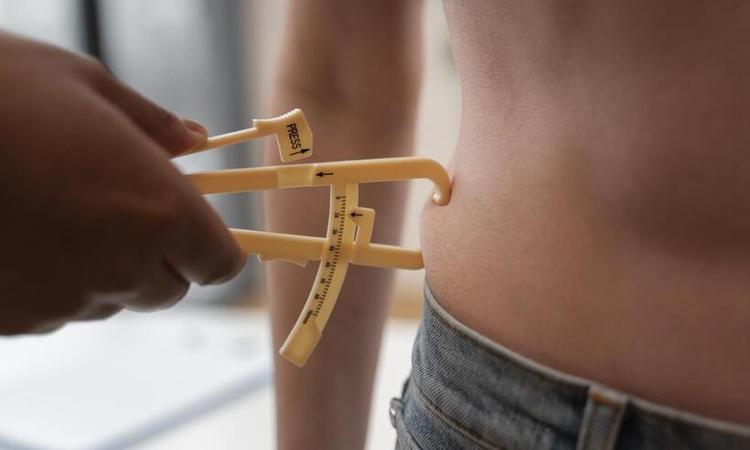 especialista medindo gordura abdominal de paciente 