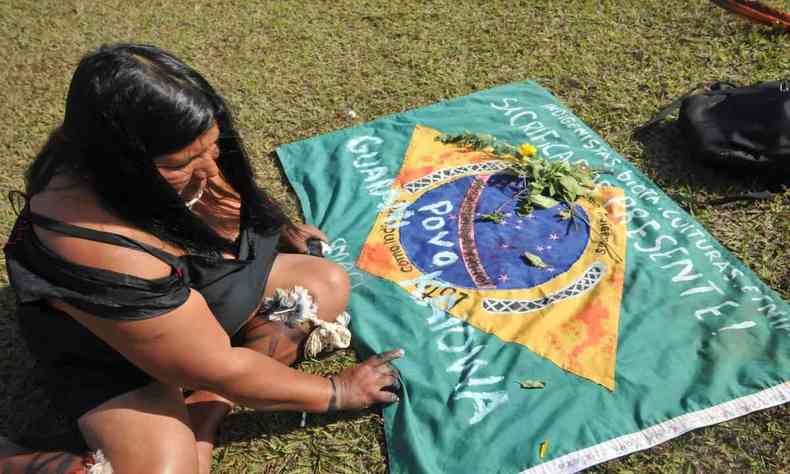Indígena com a bandeira do Brasil durante protesto 