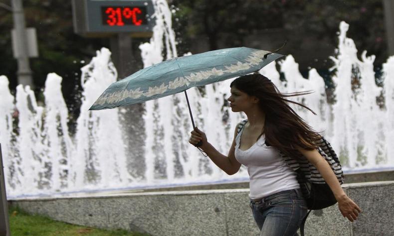 mulher com sombrinha em calor de bh