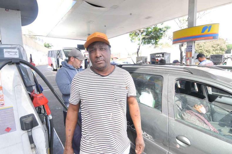 Alexandre conta que mesmo com preferência pela gasolina tem optado pelo etanol devido às condições financeiras(foto: Leandro Couri/EM/D.A Press) motorista ao lado do carro em posto de abastecimento