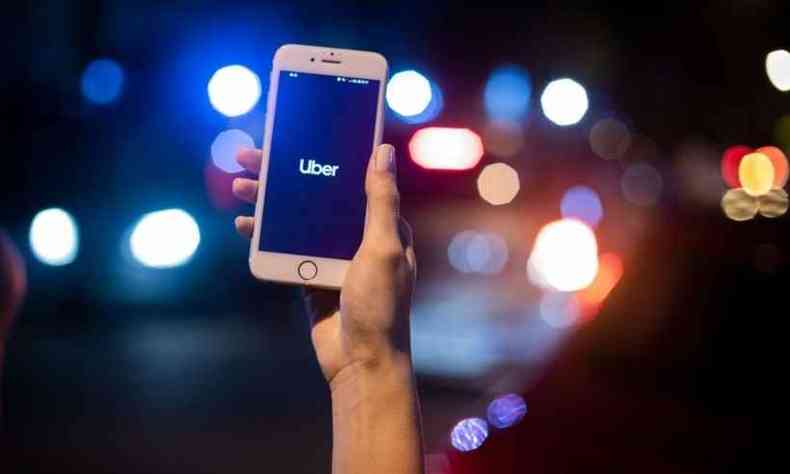 Mão de uma mulher mostra celular com o aplicativo do Uber