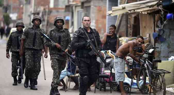 Policial guia militares por favela do complexo da mar, em preparao para a operao do exrcito(foto: Sergio Moraes/REUTERS)