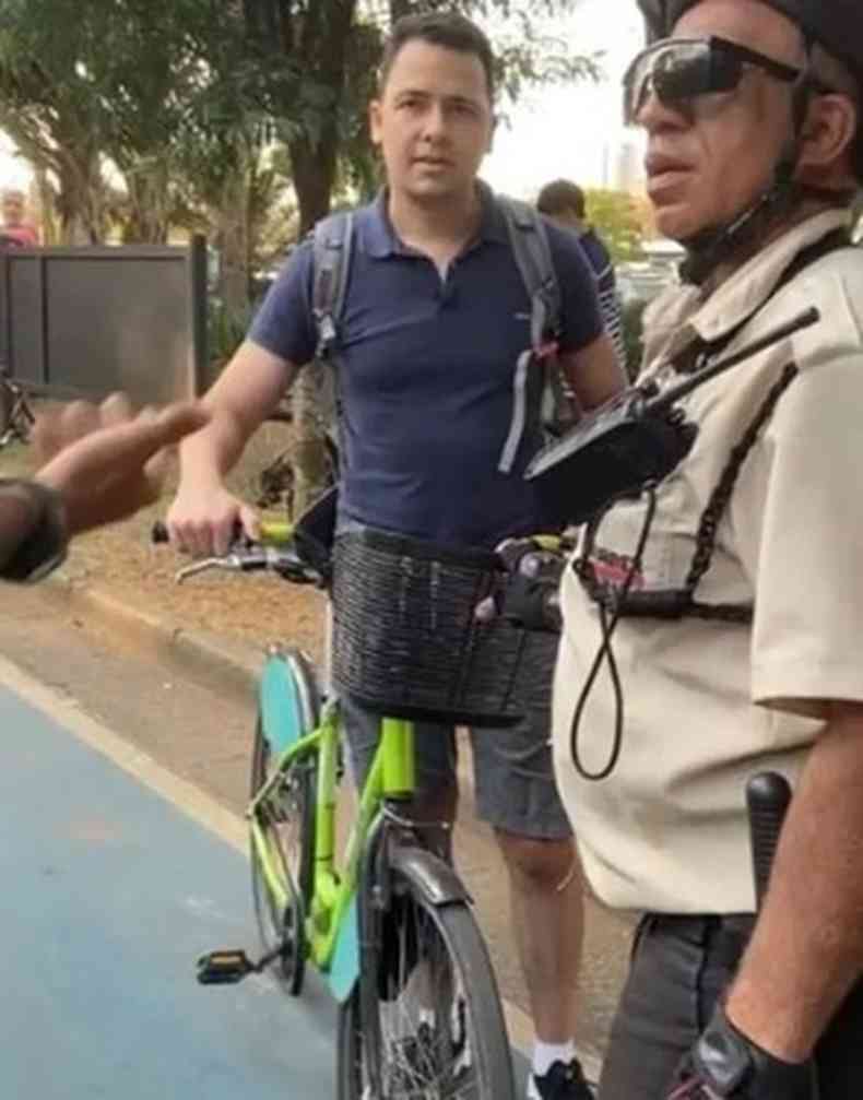 O oficial da Marinha na bicicleta ao lado de um agente da Guarda Municipal