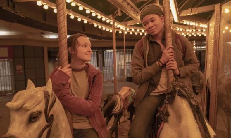 Ellie e Riley estão olhando uma para a outra em um carrossel
