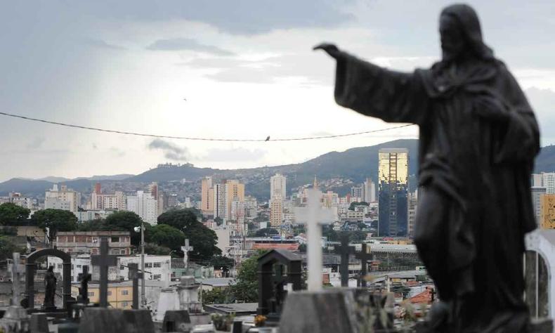 Esttua no Cemitrio do Bonfim apontando para frente, ao fundo a capital Belo Horizonte