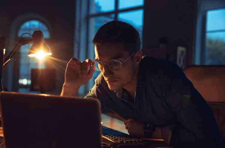 Homem trabalhando  noite em frente ao computador