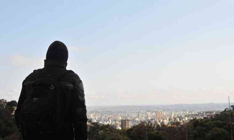 Homem agasalhado, de costas, observa a vista de Belo Horizonte 
