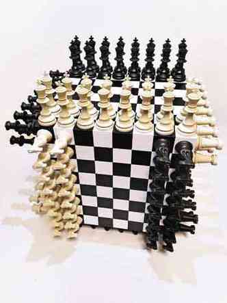 Cubo composto por seis tabuleiros de xadrez preto e branco, com suas respectivas peas, na obra ''Xadrez autocriativo'' 