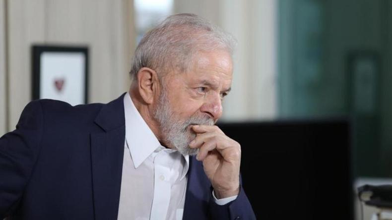 Lula de perfil com a mo fechada na boca