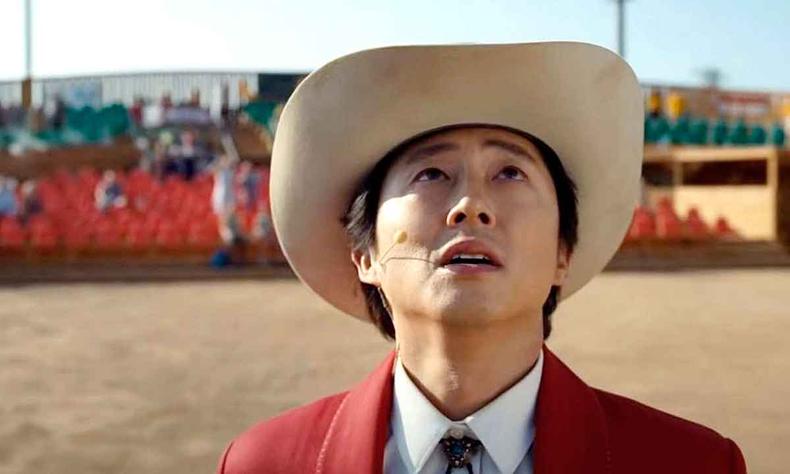 Ator Steven Yeun, usando chapu, olha para cima no filme No! No Olhe! 