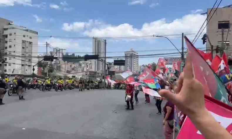 Apoiadores de Bolsonaro passam de moto por apoiadores de Lula na calada da na avenida do Contorno