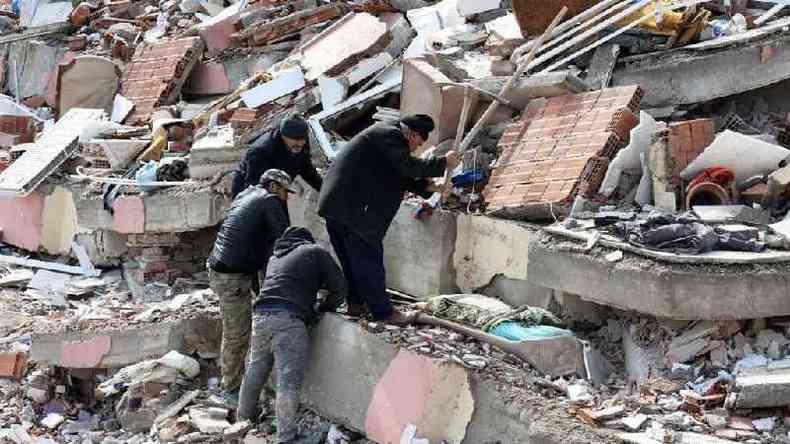 Pessoas trabalham para remover os destroos de um prdio que desabou em Kahramanmaras, perto do epicentro do terremoto