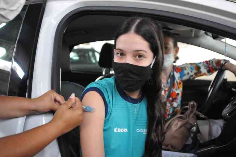 Adolescente recebe vacina contra a COVID-19 dentro do carro