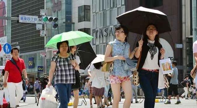 Japoneses se protegem do forte sol em Tóquio. Verão chegou mais cedo(foto: Yoshikazu TSUNO/AFP) Japoneses se protegem do forte sol em Tóquio. Verão chegou mais cedo(foto: Yoshikazu TSUNO/AFP)