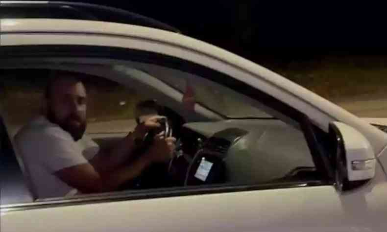 homem sendo filmado dentro de um carro 