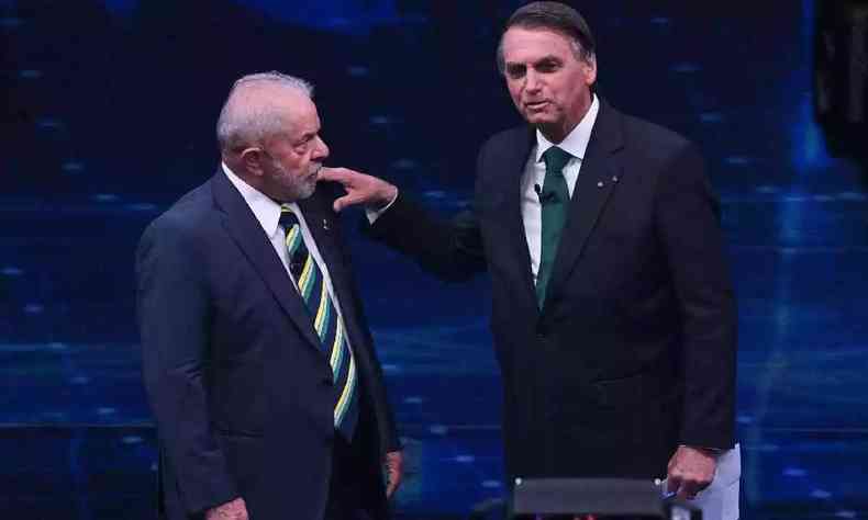 Bolsonaro coloca a mo no ombro de Lula enquanto os dois esto em p lado a lado no debate