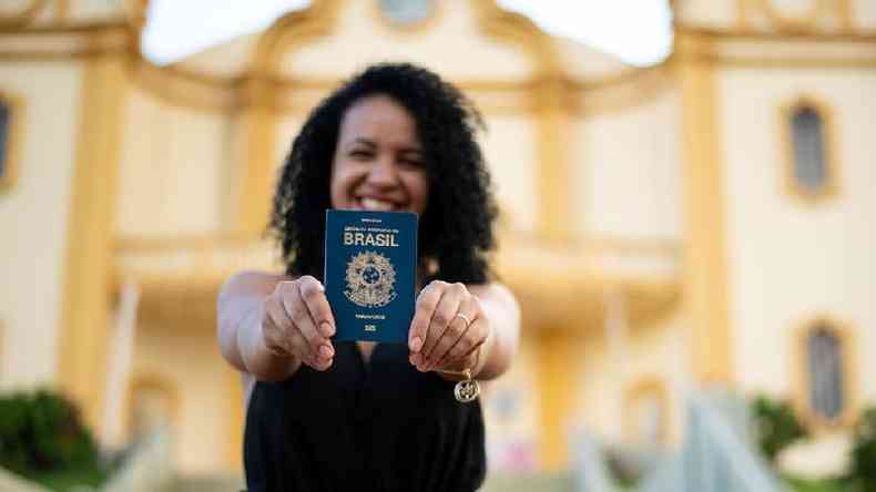 Mulher sorridente mostrando o passaporte brasileiro
