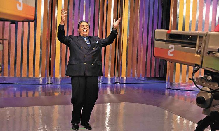 Ator Jos Rubens Chach apresenta programa de auditrio caracterizado como Silvio Santos em cena de O rei da TV