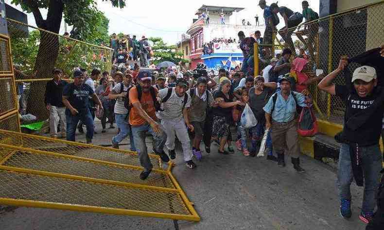 Os hondurenhos, que tentam escapar da violncia e da pobreza em seu pas, atravessaram aos gritos de 'Sim, podemos!' uma barreira de dezenas de policiais e militares que estavam com veculos blindados(foto: AFP / Pedro Pardo )