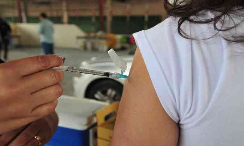 Profissional de sade faz a aplicao de vacina contra a COVID-19 em uma pessoa 