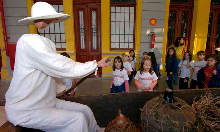 Crianas observam representao do barqueiro e sua canoa, no Museu de Artes e Ofcios
