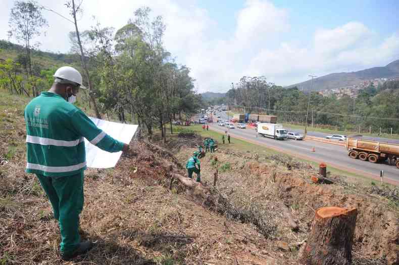 Trabalhador confere em um papel obra da rea de escape Anel Rodovirio