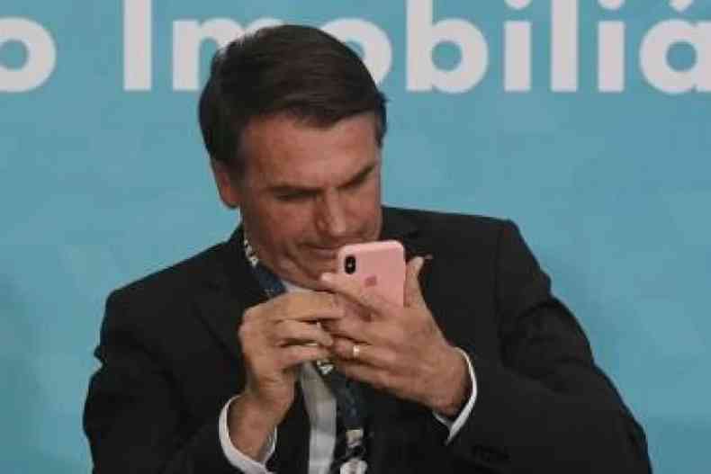 O presidente Jair Bolsonaro (PL) com celular nas mos
