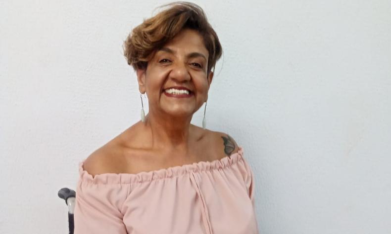 Rosana Bastos, mulher negra com cabelos curtos sentada em uma cadeira de rodas