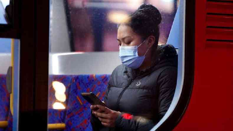 Mulher usando máscara no metrô de Londres