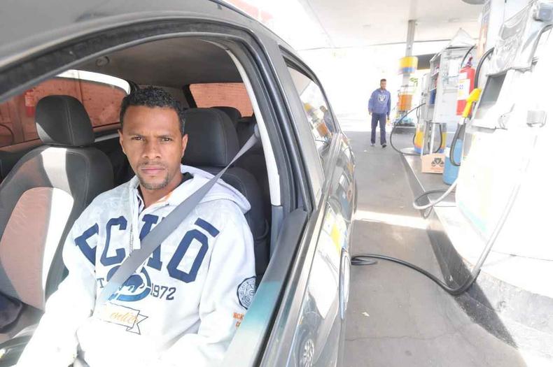 O motorista de aplicativo conta que já pensou em desistir da profissão devido a alta nos preços(foto: Leandro Couri/EM/D.A Press) Motorista sentado em carro parado no posto de gasolina