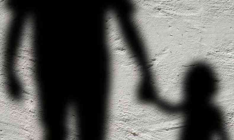 Imagem da sombra de um adulto segurando a mo de uma criana 