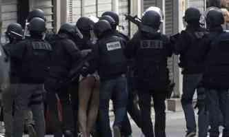Homem  conduzido por policiais aps ser preso em Saint-Denis(foto: KENZO TRIBOUILLARD/AFP)