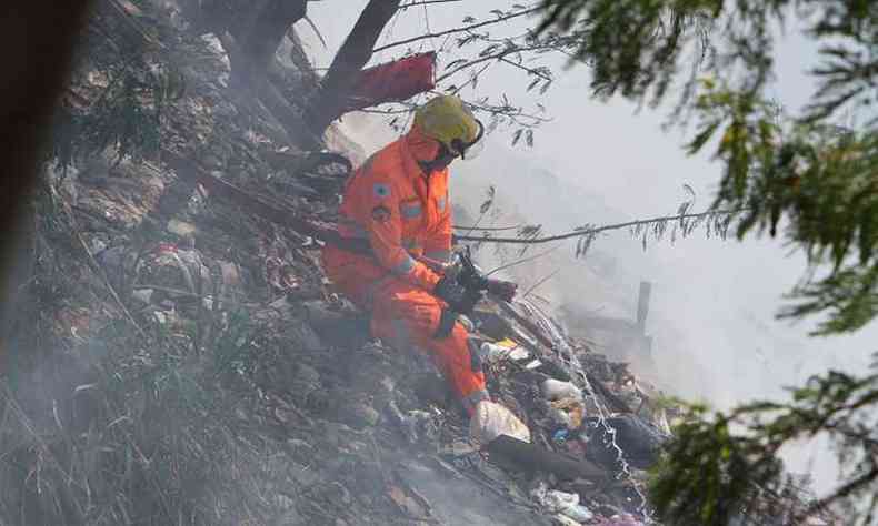 Militar no combate ao incêndio. Lote tinha depósito de lixo e materiais combustíveis(foto: Edésio Ferreira/EM/DA Press)