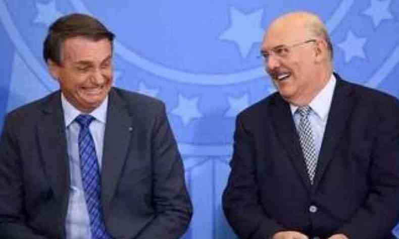 Presidente Jair Bolsonaro e o ex-ministro da Educação Milton Ribeiro riem um ao lado do outro 