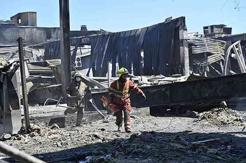 Trabalhadores limpam os escombros do shopping Amstor, um dia depois de ter sido atingido por um ataque de mssil russo