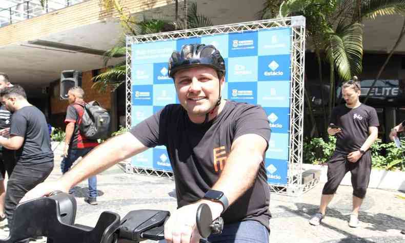 homem de camisa preta, com capacete e sentado na bicicleta 