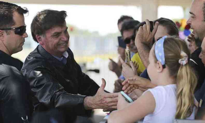 O presidente Jair Bolsonaro chega de moto ao Palcio da Alvorada e cumprimenta turistas (foto: Marcello Casal Jr./Agncia Brasil )