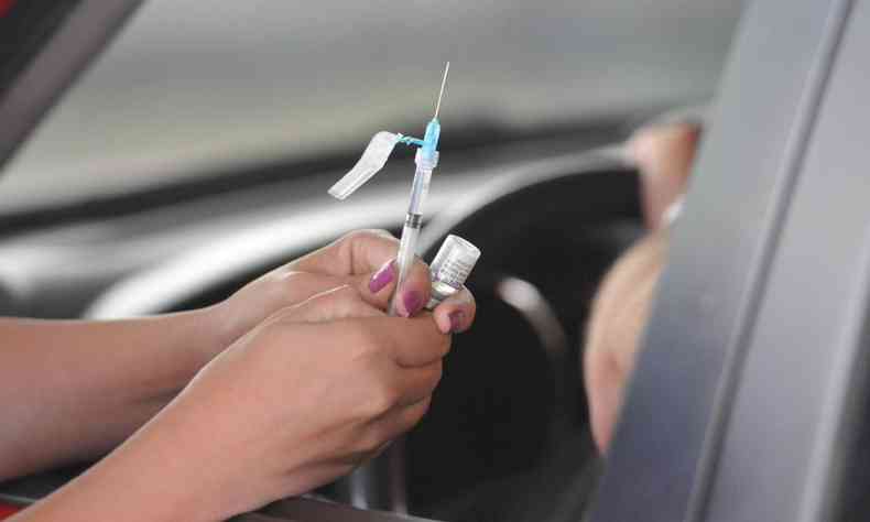 Enfermeira prepara aplicao de vacina contra COVID-19 em drive-thru