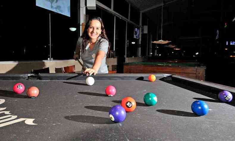 Mão do homem jogando sinuca no bar com bola de snooker