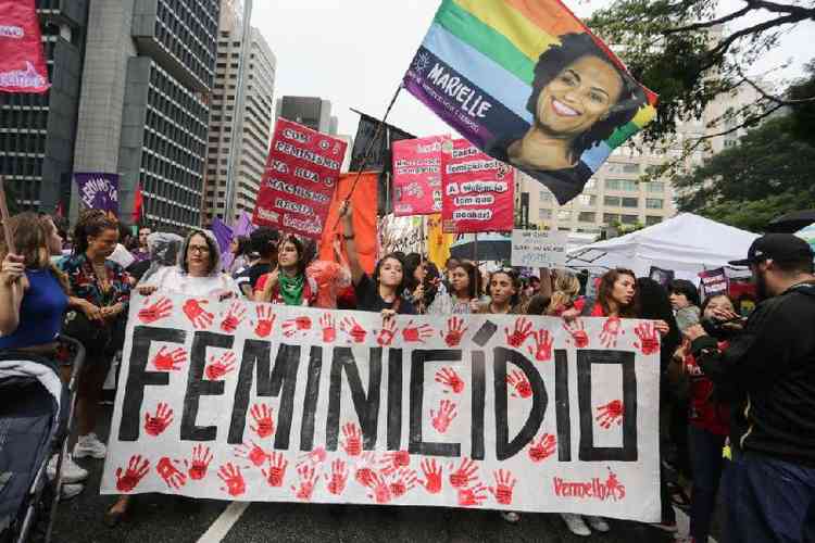 Mulheres seguram cartaz com a palavra feminicdio e foto de Marielle Francoem manifestao feminista em So Paulo