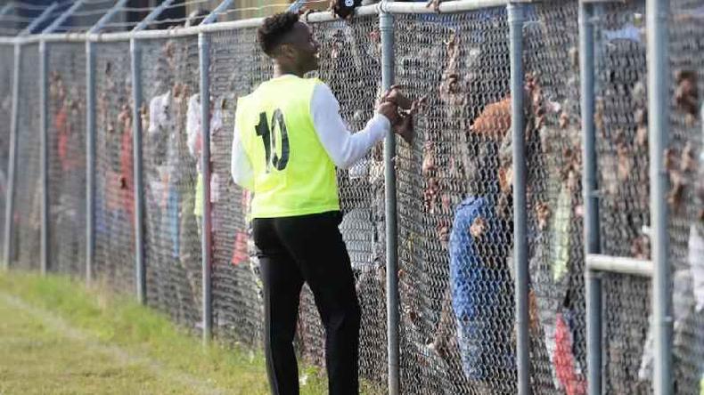 O jogador de futebol da Inglaterra Raheem Sterling também cumprimentou os fãs que foram ver ele e o príncipe William jogar futebol(foto: Getty Images) Raheem Sterling cumprimenta fãs por meio de uma cerca de metal